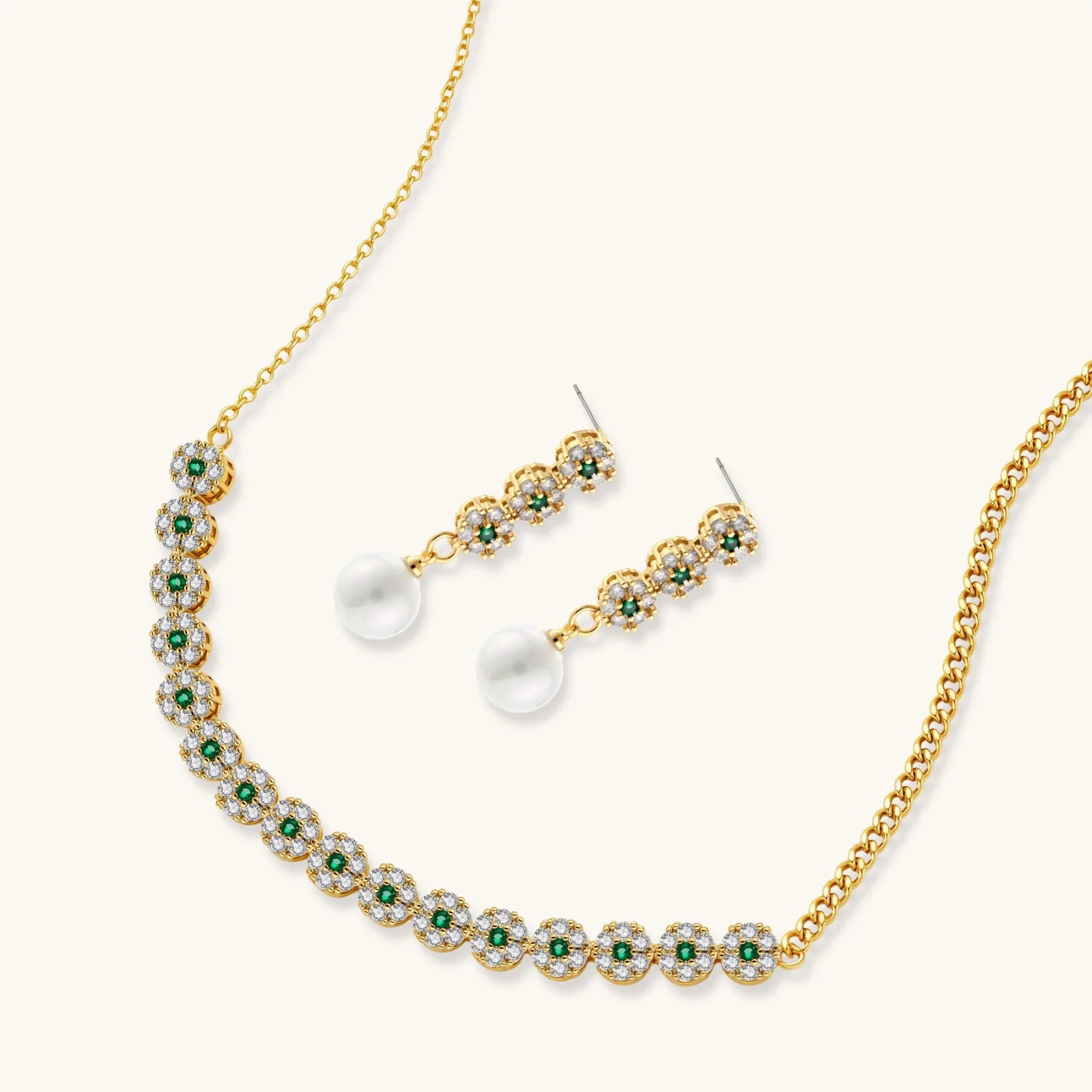 Gold-plated jewelry set with green cubic zirconia floral motifs, featuring matching necklace and pearl drop earrings