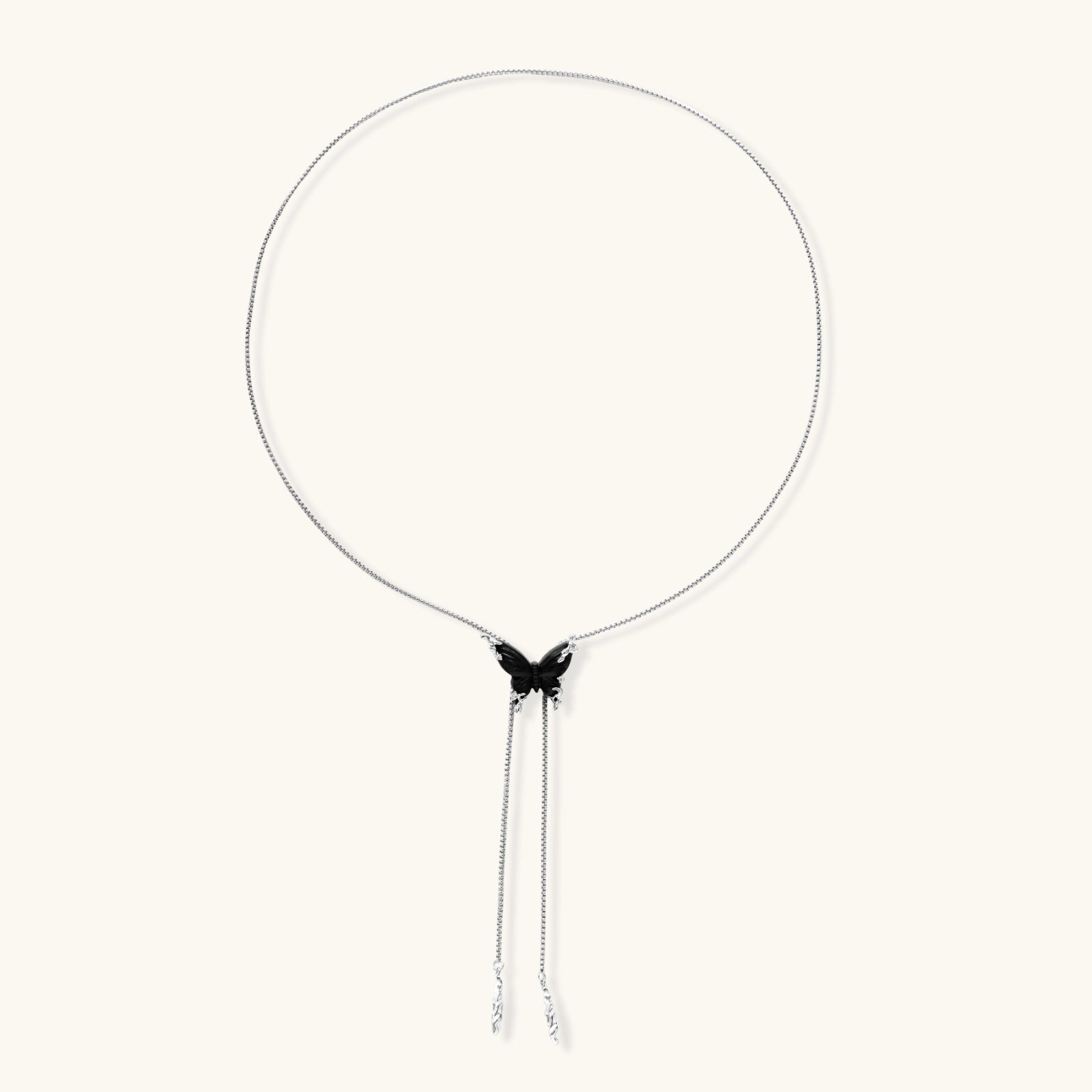 Wooden butterfly pendant necklace with cascading silver-toned chains on adjustable chain, available in amber and black.