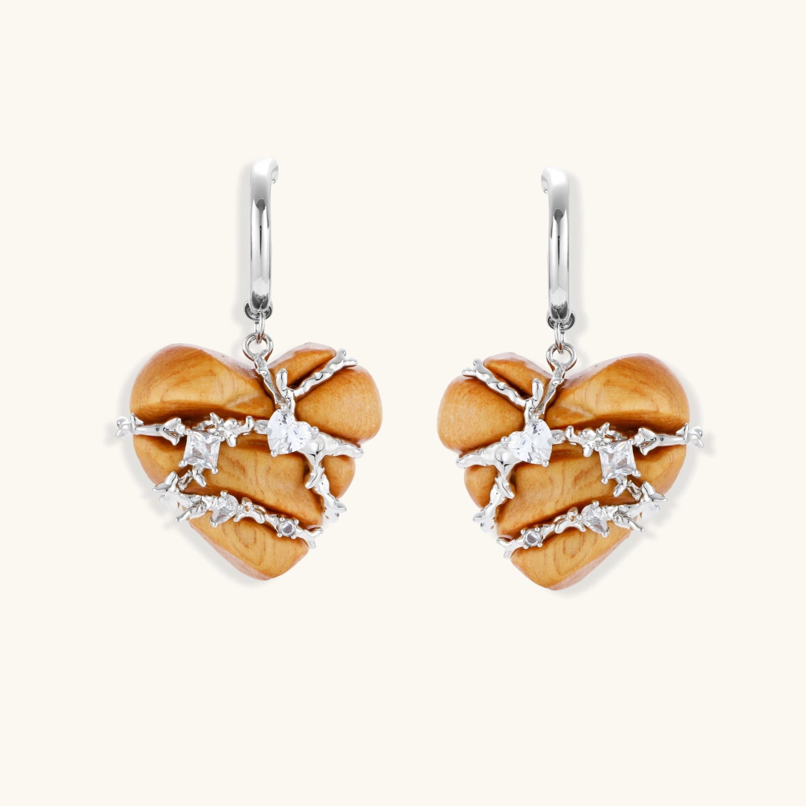 Heart-shaped wood earrings wrapped in silver wire with zirconia crystals, featuring ball stud posts on white background.