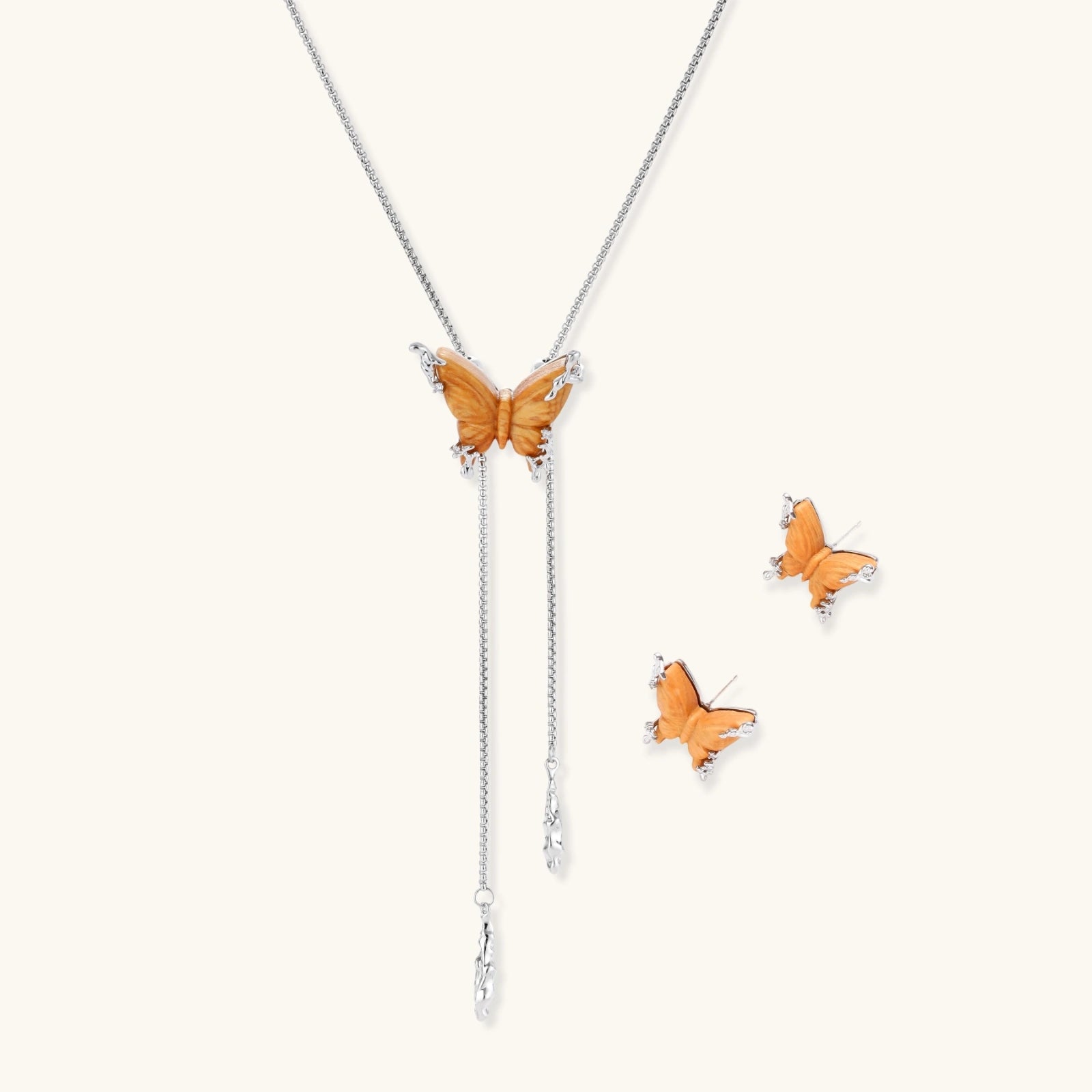 Amber wood butterfly pendant necklace with dangling chains and matching carved wood butterfly earrings on white background.