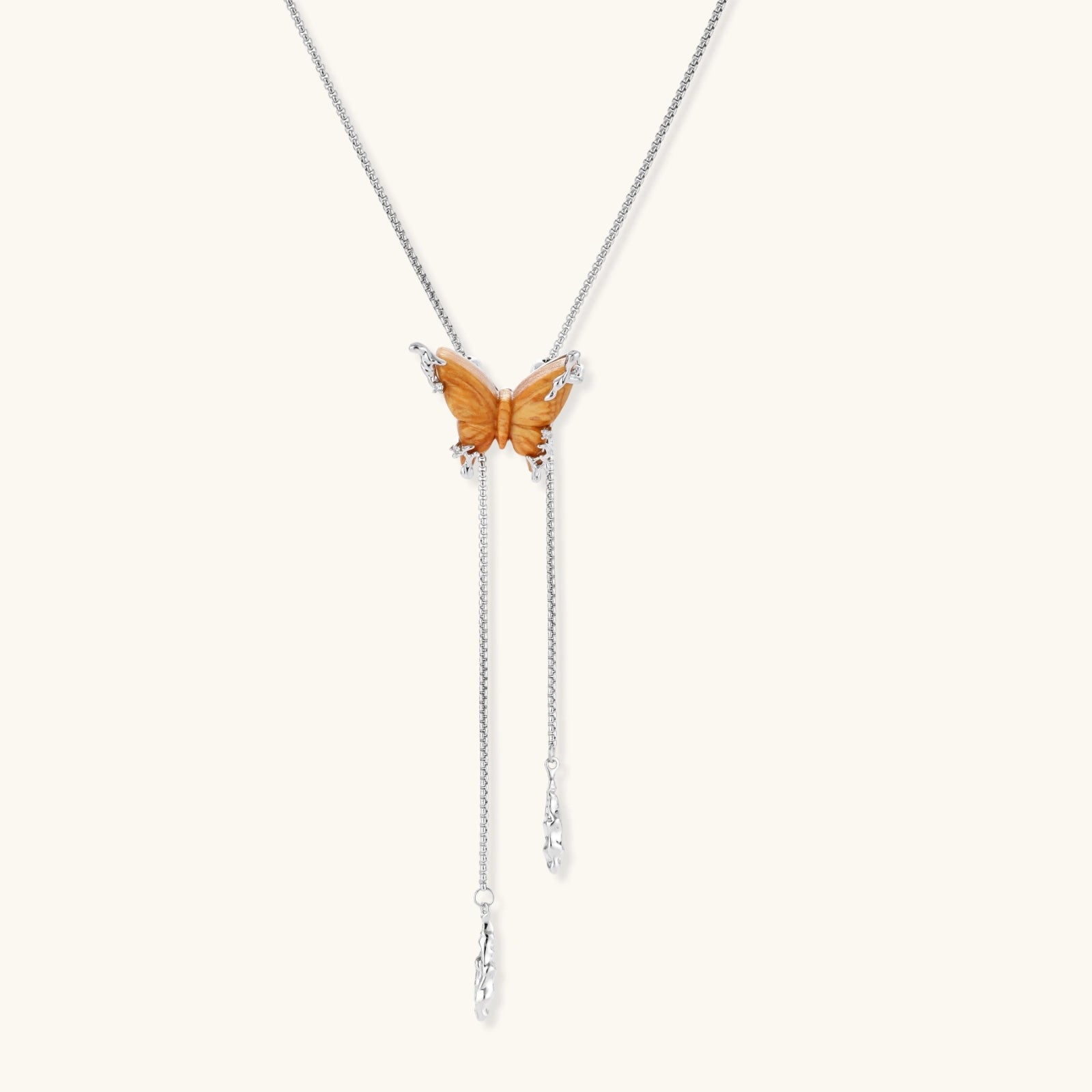 Amber wood butterfly pendant necklace with dangling chains and matching carved wood butterfly earrings on white background.