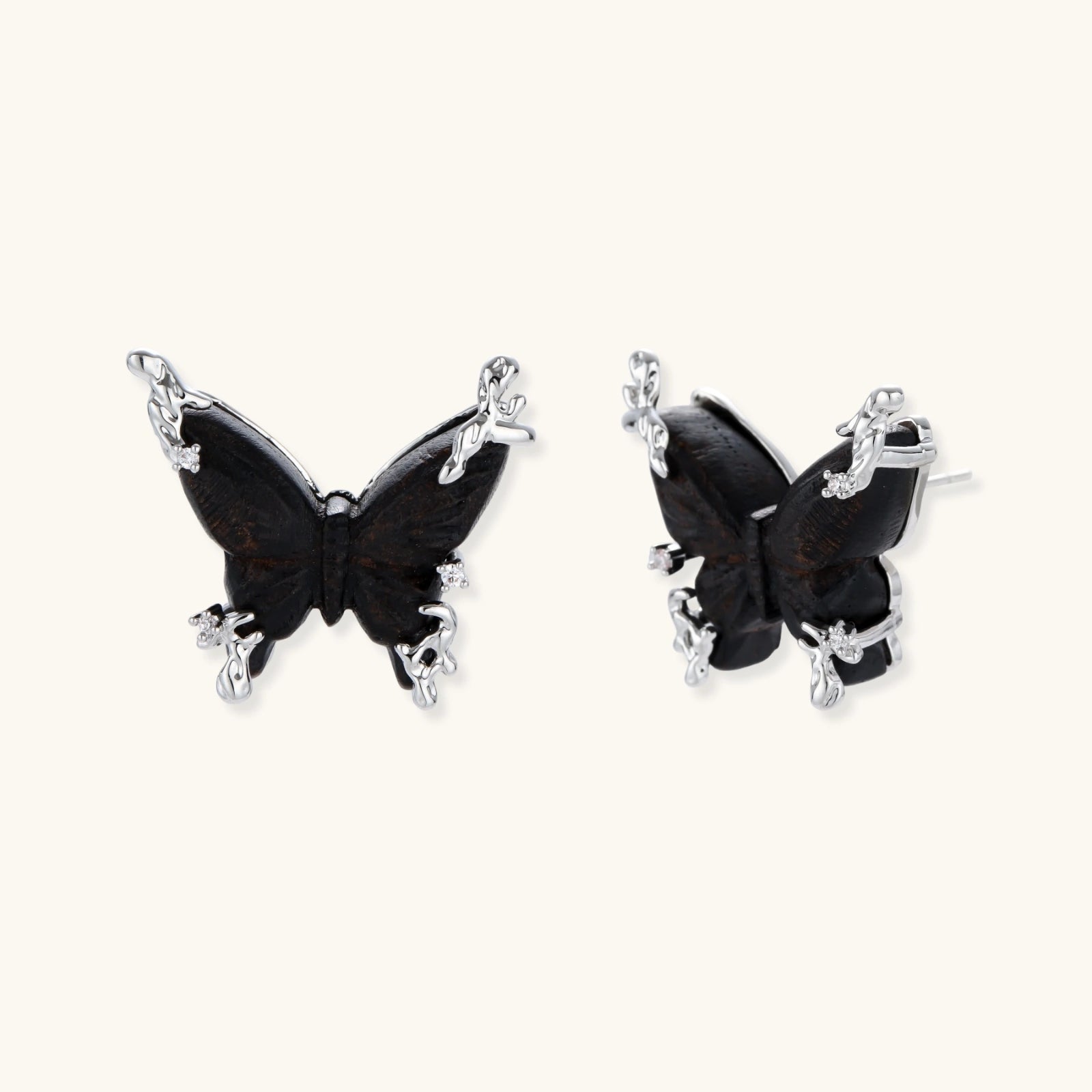 Dark wood butterfly earrings and necklace with silver chain accents on white background, showing natural grain texture.