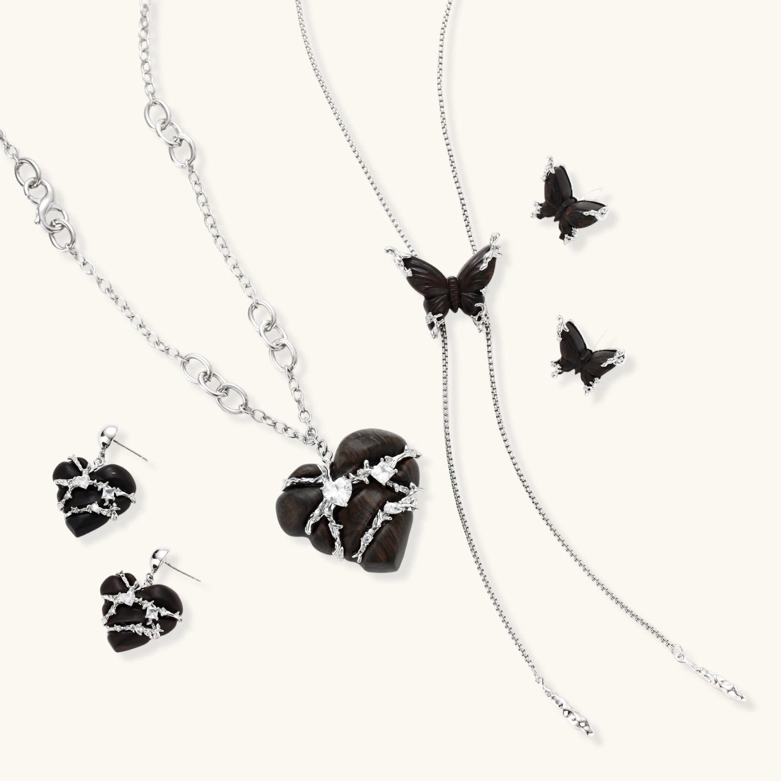 Dark wood butterfly earrings and necklace with silver chain accents on white background, showing natural grain texture.