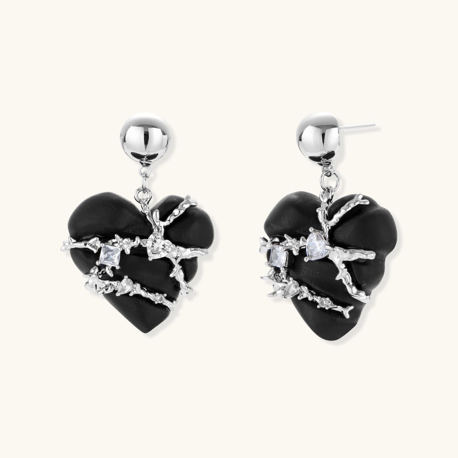 Dark ebony wood heart charms wrapped in intricate silver chains with crystal accents, shown as matching earrings and necklace set.
