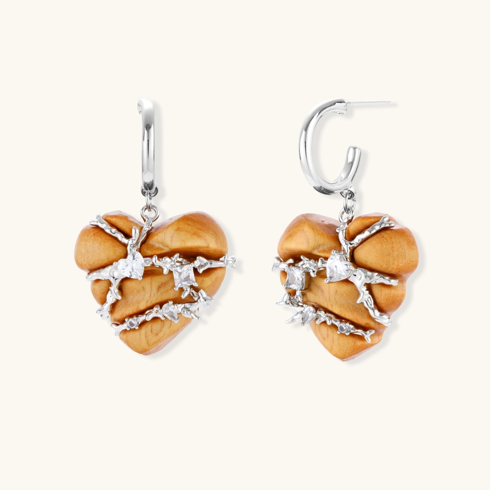 Heart-shaped eco-brass and wood jewelry set with silver wire detailing and crystal accents on cream background.