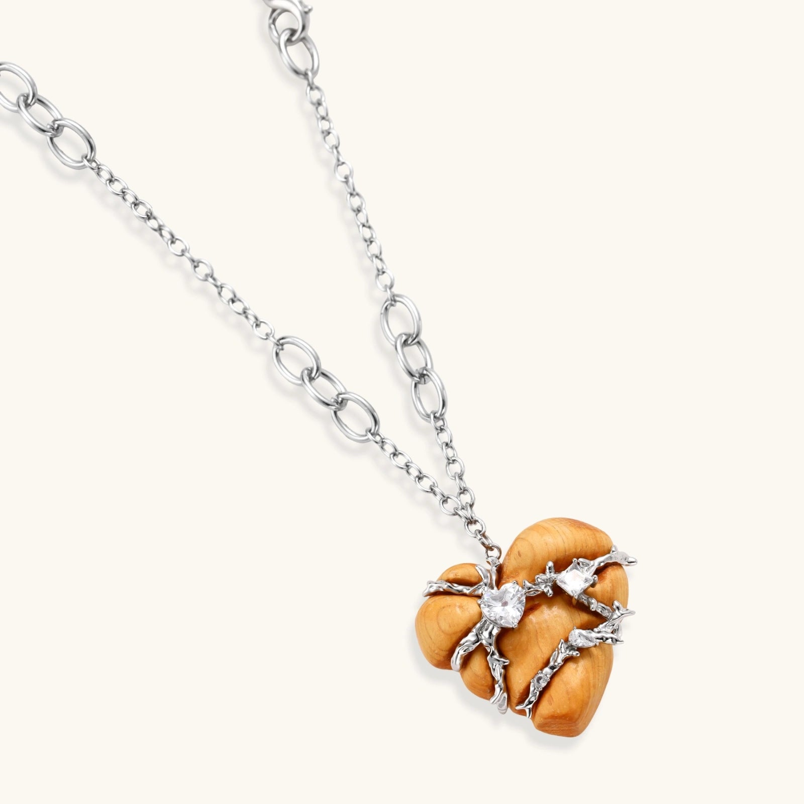 Heart-shaped eco-brass and wood jewelry set with silver wire detailing and crystal accents on cream background.