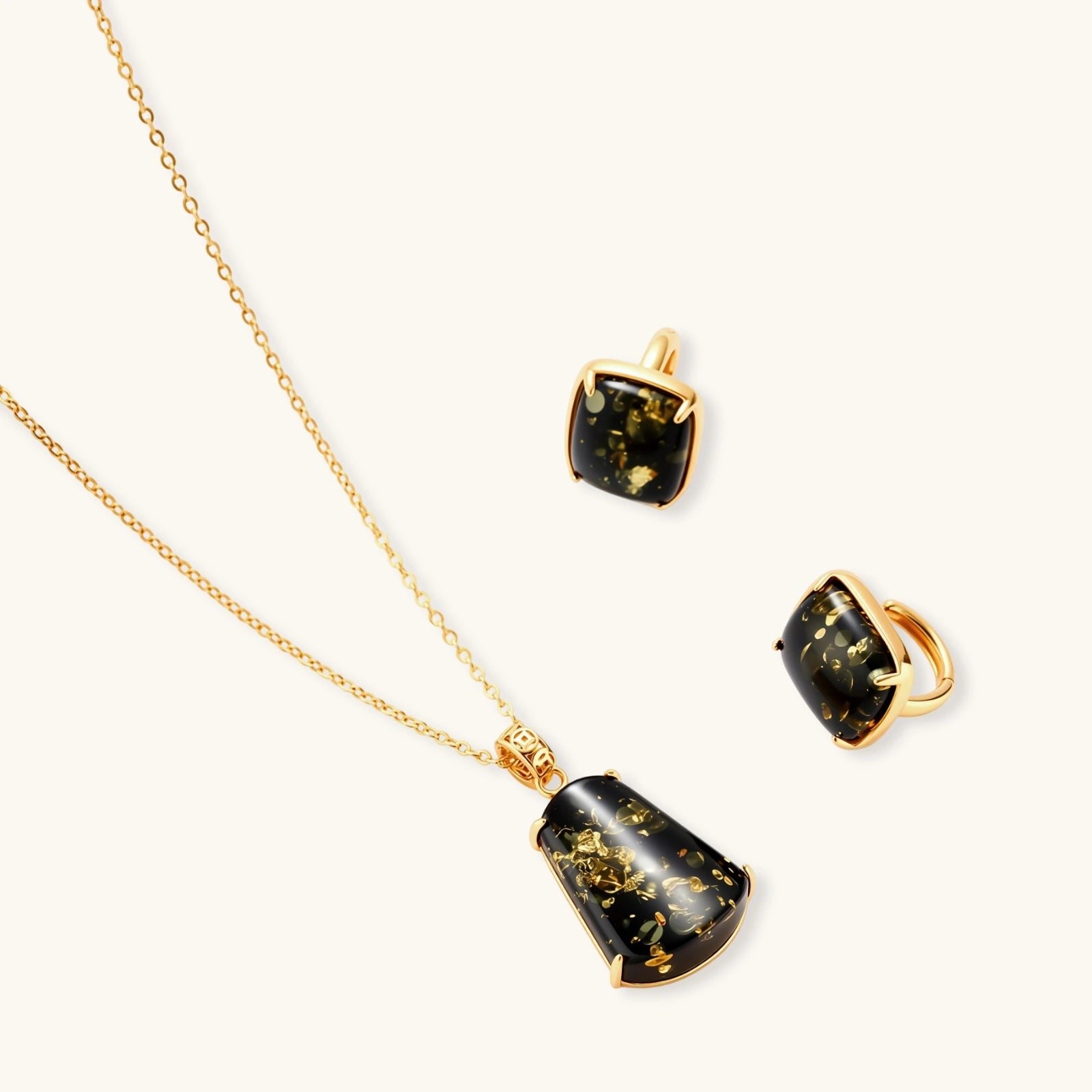 18k gold-plated necklace and earrings with green amber pendants featuring golden inclusions on cream background